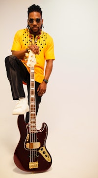a man posing with a bass guitar in front of a white background