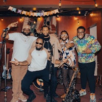 a group of men posing in front of a microphone